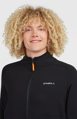 Junger Mann mit lockigem blondem Haar trägt eine schwarze Jacke mit O'Neill-Logo.