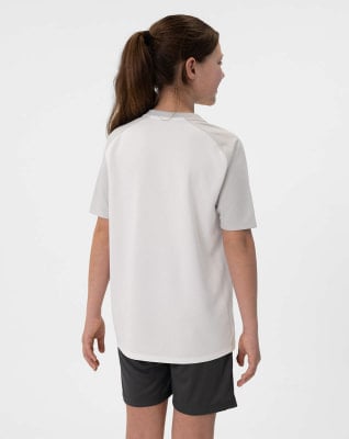 Mädchen in einem weißen Kurzarmshirt und dunklen Shorts.