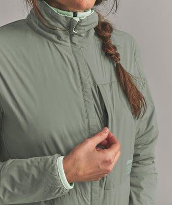 Detail einer Damenjacke mit Tasche und hellgrünem Kragen. Detail einer Damenjacke mit Tasche und hellgrünem Kragen.