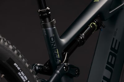Detail des Hinterbaus eines Mountainbikes mit Dämpfer und Aufschrift ONE. Detail des Hinterbaus eines Mountainbikes mit Dämpfer und Aufschrift ONE.