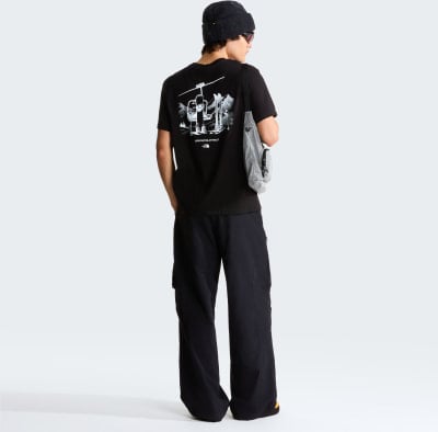 Mann in schwarzem T-Shirt mit Aufdruck und schwarzer Hose mit Tasche. Mann in schwarzem T-Shirt mit Aufdruck und schwarzer Hose mit Tasche.