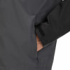 Detail einer Herrenjacke mit Tasche und Klettverschluss am Ärmel.