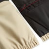 Zwei Stoffe, beige und schwarz, mit roter Naht.
