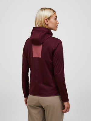 Rückansicht einer Frau in einem burgunderroten Kapuzenpullover und beiger Hose. Rückansicht einer Frau in einem burgunderroten Kapuzenpullover und beiger Hose.