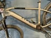 Grauer E-Bike-Rahmen mit CUBE-Logo und schwarzen Pedalen.