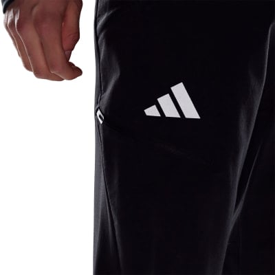 Detail einer schwarzen Sportjacke mit Adidas-Logo und Reißverschlusstasche. Detail einer schwarzen Sportjacke mit Adidas-Logo und Reißverschlusstasche.