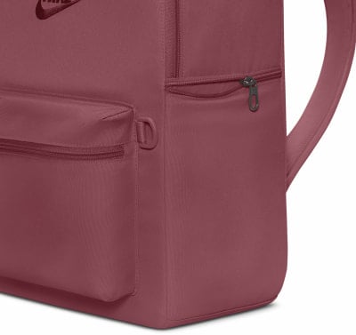 Detail eines Nike-Rucksacks mit Reißverschlusstasche vorne und Logo.