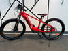 Ein rotes KTM E-Bike mit schwarzen Rädern und Federung auf einem Ständer.