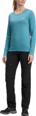 Eine Frau in einem blauen Langarmshirt und schwarzer Hose, trägt Wanderschuhe. Eine Frau in einem blauen Langarmshirt und schwarzer Hose, trägt Wanderschuhe.