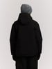 Rückansicht einer Person in schwarzer Kapuzenjacke und grauem Beanie.