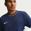 Ein Mann in einem dunkelblauen T-Shirt mit weißem Nike-Logo und Kragen.