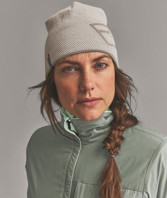 Eine Frau in einer Strickmütze und grüner Jacke mit Zopf. Eine Frau in einer Strickmütze und grüner Jacke mit Zopf.