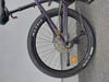 Lila Mountainbike mit schwarzen Maxxis-Reifen und Kassette am Hinterrad.