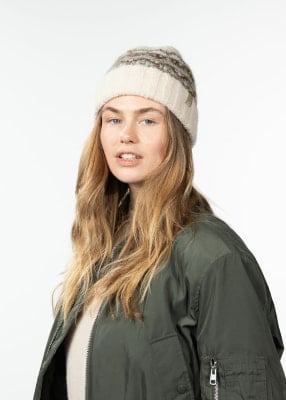 Eine Frau mit langen Haaren trägt eine grüne Jacke und eine gestreifte Mütze. Eine Frau mit langen Haaren trägt eine grüne Jacke und eine gestreifte Mütze.