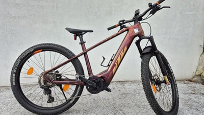 Ein rotes KTM E-Mountainbike mit Federung und Display am Lenker. Ein rotes KTM E-Mountainbike mit Federung und Display am Lenker.