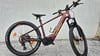 Ein rotes KTM E-Mountainbike mit Federung und Display am Lenker.