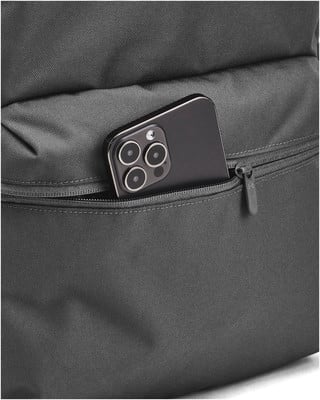Schwarzes Smartphone mit Dreifachkamera in der Vordertasche eines Rucksacks. Schwarzes Smartphone mit Dreifachkamera in der Vordertasche eines Rucksacks.