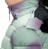 Ein Mädchen trägt eine hellgrüne Daunenjacke mit lila Muster.