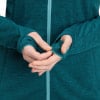 Detail der Hände in dunkel-türkisfarbenem Fleece-Kleidungsstück mit Daumenlöchern.