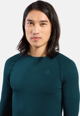 Ein Mann mit langen dunklen Haaren in einem dunkelgrünen Langarmshirt. Ein Mann mit langen dunklen Haaren in einem dunkelgrünen Langarmshirt.