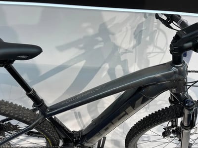 Detail eines dunkelgrauen E-Bike-Rahmens mit der Aufschrift Powerfly. Detail eines dunkelgrauen E-Bike-Rahmens mit der Aufschrift Powerfly.