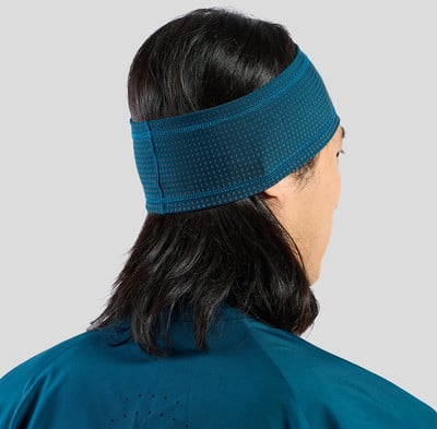 Ein Mann mit dunklen Haaren trägt ein blaues Stirnband und ein dunkelblaues Shirt.