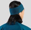 Ein Mann mit dunklen Haaren trägt ein blaues Stirnband und ein dunkelblaues Shirt.