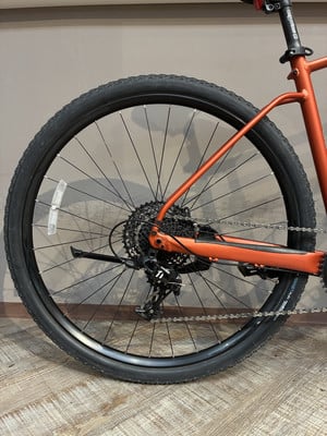 Hinterrad eines orangefarbenen Fahrrads mit Kassette und Schaltwerk. Hinterrad eines orangefarbenen Fahrrads mit Kassette und Schaltwerk.