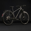 Ein schwarzes Cube Fahrrad mit Schutzblechen und Gepäckträger vor schwarzem Hintergrund.