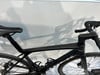 Ein schwarzes Rennrad mit tropfenförmigem Rahmen und Schattenwurf an der Wand.