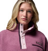 Frau im pinkfarbenen Fleece-Pullover mit Knöpfen und Columbia-Logo.