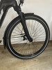Vorderreifen eines schwarzen E-Bikes mit Schutzblech und Scheibenbremse.