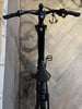 Ein schwarzes E-Bike mit Display am Lenker und gedämpfter Beleuchtung.