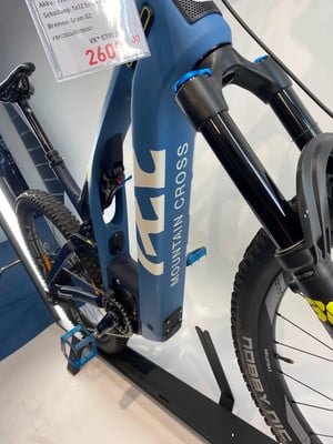 Blaues Mountain-E-Bike mit Preisschild 2600,00 und Schriftzug MOUNTAIN CROSS. Blaues Mountain-E-Bike mit Preisschild 2600,00 und Schriftzug MOUNTAIN CROSS.