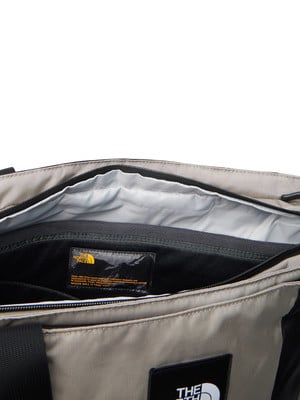 Das Innere einer beige Tasche mit dem Logo von The North Face und einem Textetikett.