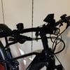 Lenker eines dunkelblauen E-Bikes mit Bremshebeln und Licht.