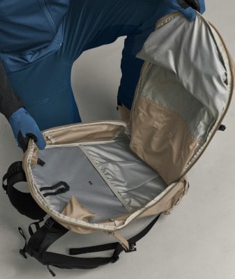 Offener Rucksack mit beige-farbenem Äußeren und grauem Inneren. Offener Rucksack mit beige-farbenem Äußeren und grauem Inneren.