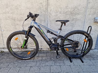 Ein E-Mountainbike mit Federung und Scheibenbremsen steht auf einem Ständer. Ein E-Mountainbike mit Federung und Scheibenbremsen steht auf einem Ständer.