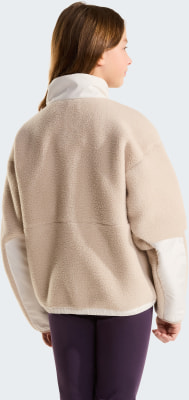 Mädchen in beiger Fleecejacke mit weißem Kragen und dunkelvioletten Leggings.