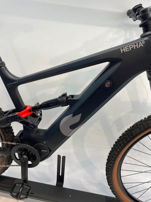 Teil eines schwarzen E-Bikes mit HEPHA-Logo und Dämpfer Teil eines schwarzen E-Bikes mit HEPHA-Logo und Dämpfer