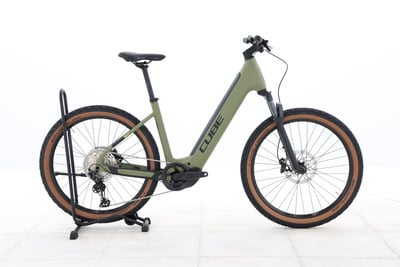 Grünes Cube E-Bike mit braunen Reifen auf einem Ständer.