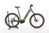 Grünes Cube E-Bike mit braunen Reifen auf einem Ständer.