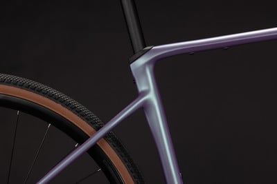 Detail eines Fahrradrahmens mit schillernder Lackierung und einem Teil des Hinterrads. Detail eines Fahrradrahmens mit schillernder Lackierung und einem Teil des Hinterrads.