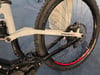 Das Hinterteil eines weißen Mountain-E-Bikes mit Federung und schwarzem Motor.