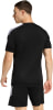 Ein Mann in einem schwarzen T-Shirt mit weißen Streifen an den Schultern und Shorts.