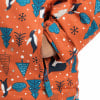Eine geschlossene Tasche an einer Jacke mit Pinguin- und Weihnachtsbaumdruck.