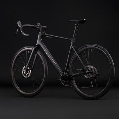 Schwarzes Carbon-Rennrad mit Scheibenbremsen auf schwarzem Hintergrund. Schwarzes Carbon-Rennrad mit Scheibenbremsen auf schwarzem Hintergrund.