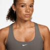 Das Model trägt einen grauen Nike Sport-BH mit Logo.
