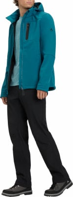 Mann in dunkelblauer Jacke und schwarzer Hose mit Wanderschuhen.