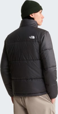 Mann von hinten in schwarzer Daunenjacke und grüner Mütze mit The North Face Logo. Mann von hinten in schwarzer Daunenjacke und grüner Mütze mit The North Face Logo.